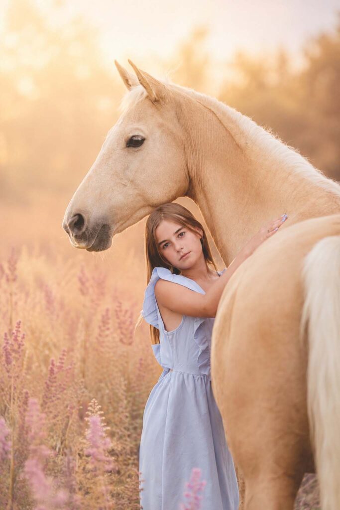 A young girl embracing a golden horse, the quiet connection at the heart of an equine session