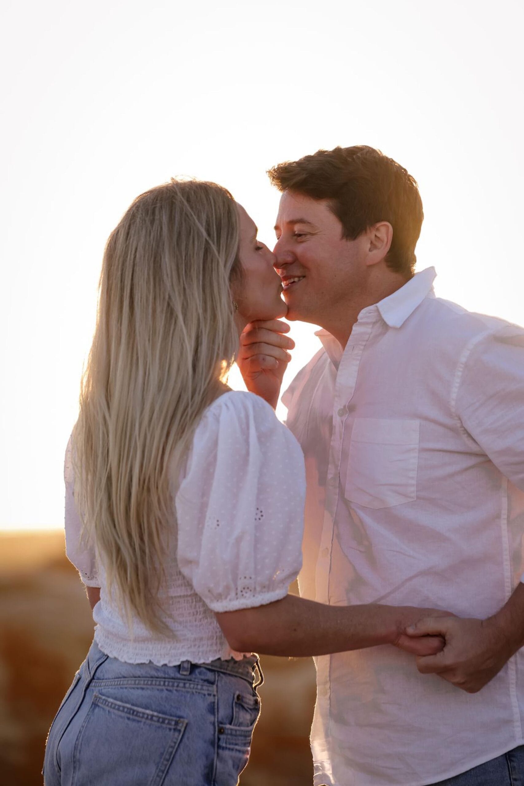 Couple sharing a gentle kiss in golden-hour light during a couple photoshoot on the Eastern Cape coast by Adri Krige Photography