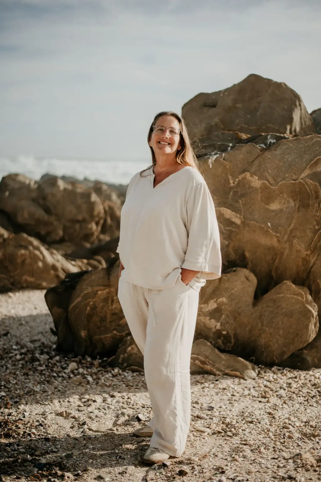 Adri Krige, family and couple photographer, smiling on the rocky beach in St Francis Bay, Eastern Cape