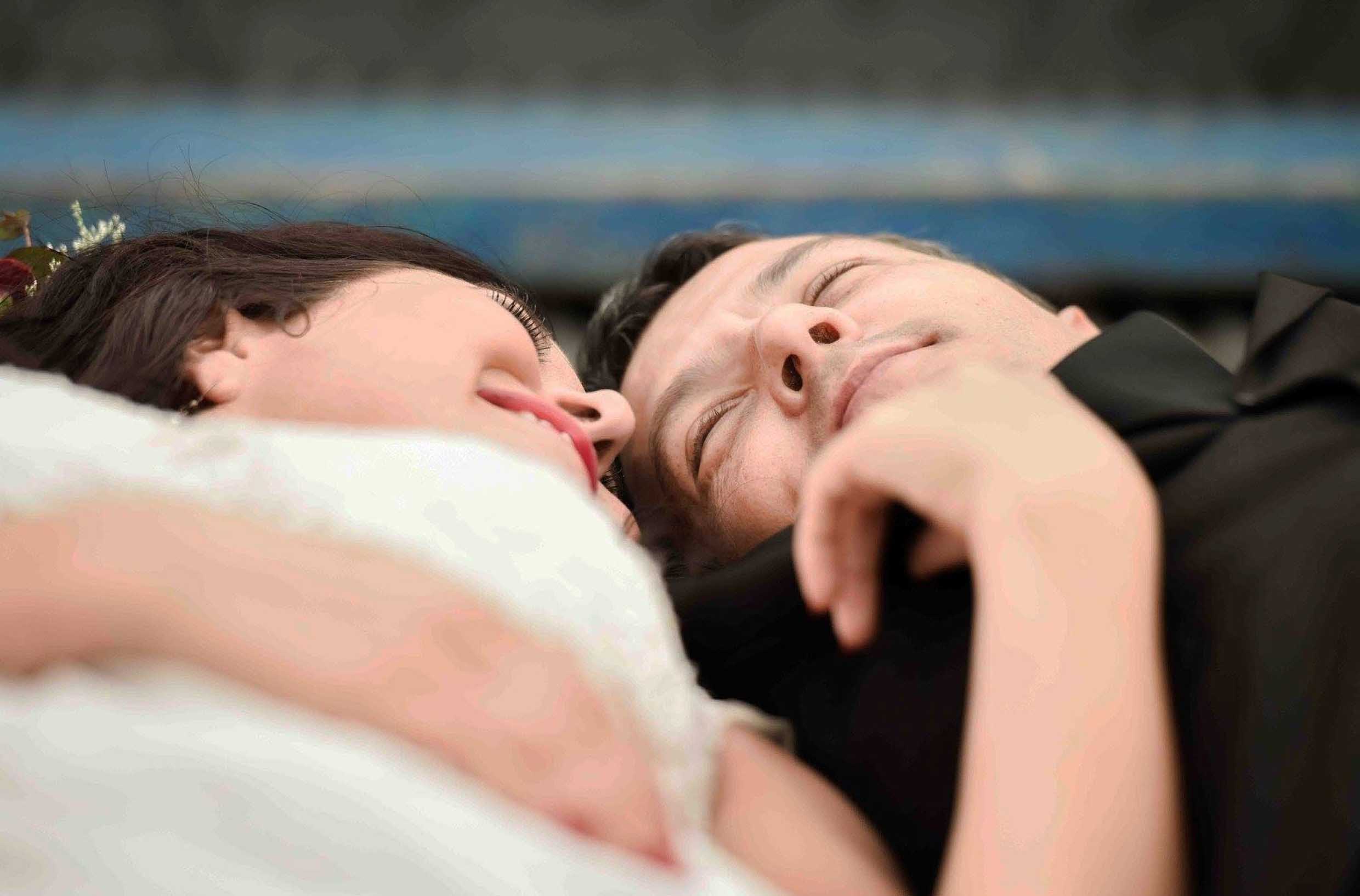 Bride and groom lying side by side with eyes closed and peaceful smiles, her arm resting across his chest, a quiet intimate wedding moment, wedding photography by Adri Krige, Eastern Cape wedding photographer