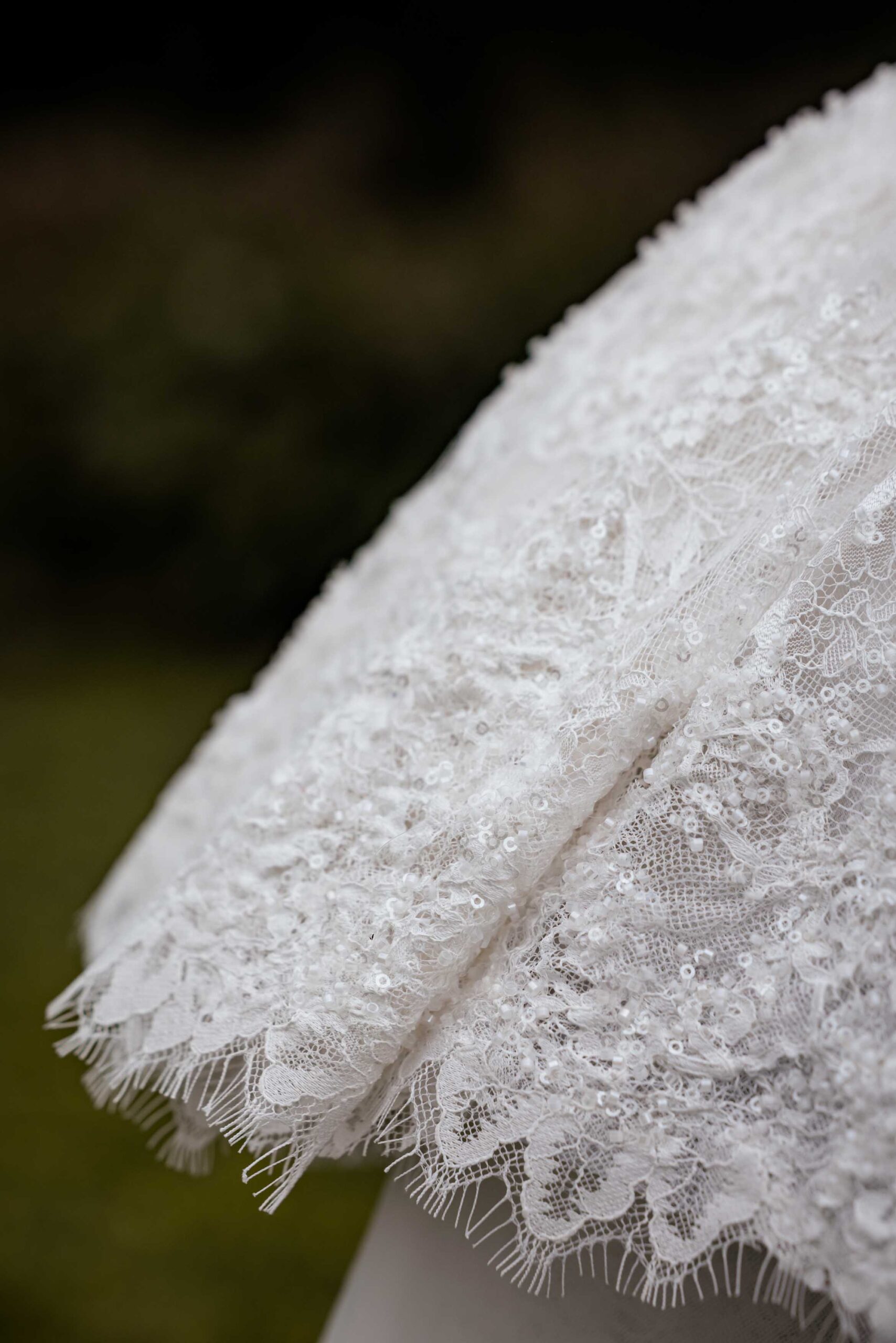 Close-up of the delicate beaded lace and scalloped eyelash lace edge on a bride’s wedding dress sleeve, wedding detail photography by Adri Krige, Eastern Cape wedding photographer